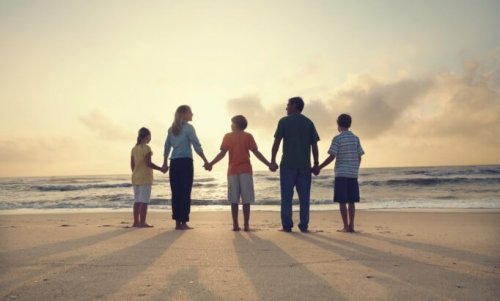 A family holding hands at the beach.