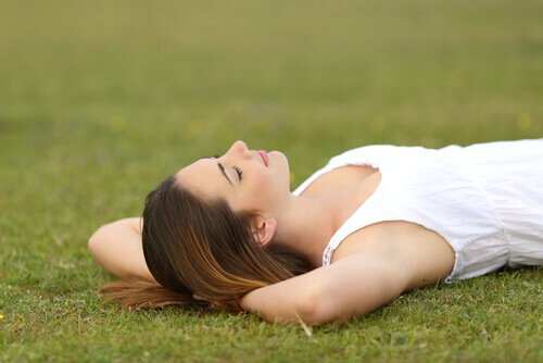 A woman relaxing on the grass.