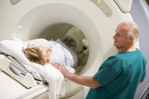 læge, der gør dame klar til MRI-scanning