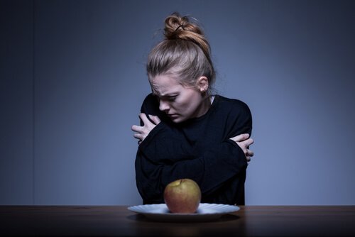 Woman with anorexia feeling bad in front of food.
