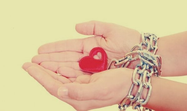 Hands chained to a heart.