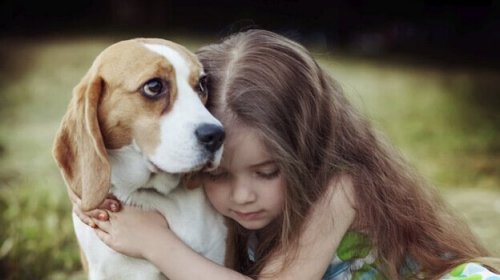 A girl hugging a dog.