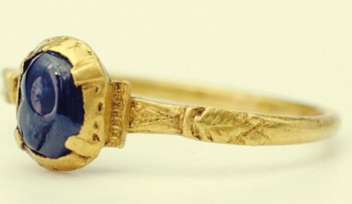 A gold ring with a blue stone.