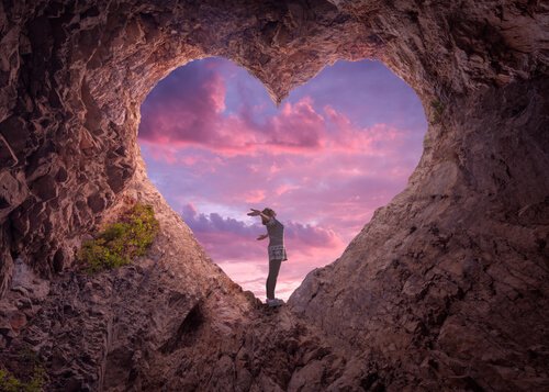 A woman standing on a heart-shaped rock.