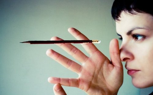 A girl suspending a pencil with her eyes.