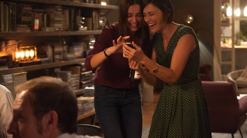 Girlfriend looking at their phones laughing.