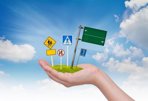 A hand holding street signs.