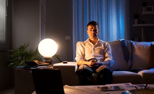 Man with insomnia sitting on his couch.