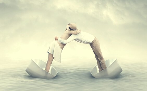 Two people embracing from different boats.