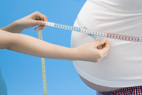 A person measuring another person's obese belly.
