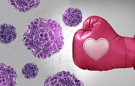 A pink boxing glove punching cancer cells.