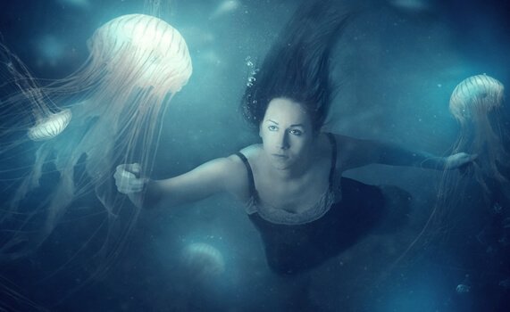 Woman swimming with jellyfish.