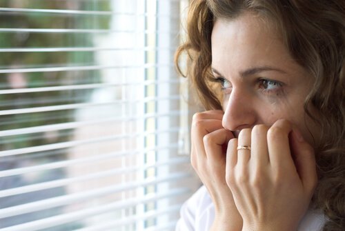 A woman with panophobia looking out the window.