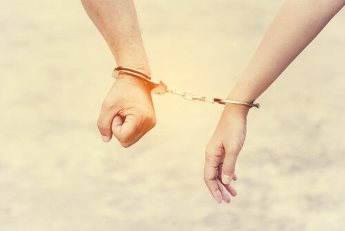 A couple connected by handcuffs.