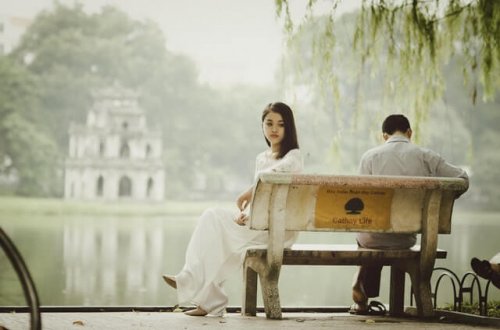 Girl sitting on a bench feeling lonely.