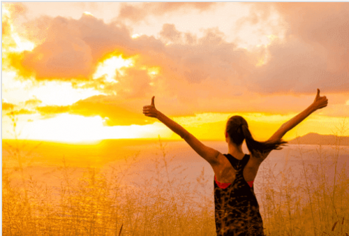 Motivated woman looking at the sunrise.