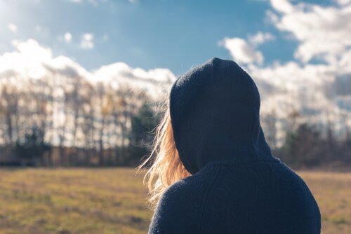 A teen girl looking at the forest.