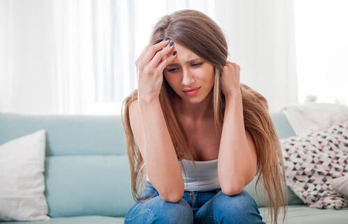 A woman sitting down, angry with herself.