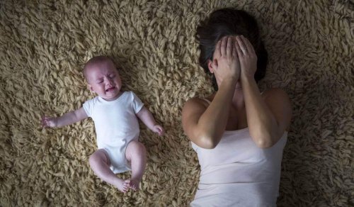 Woman lying on the floor next to her crying baby.