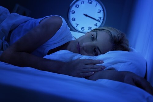 Woman in bed wakes up in bed in the middle of the night.