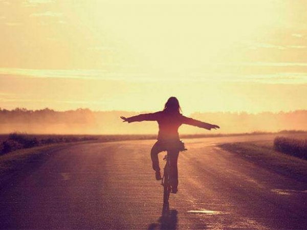 A woman riding a bike on a path.