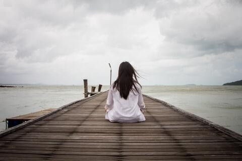 woman sitting in front of the sea