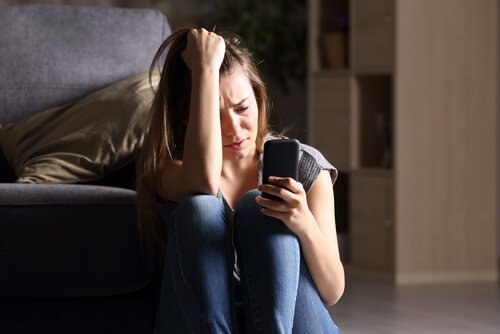 Girl with FOMO syndrome staring at her smartphone.
