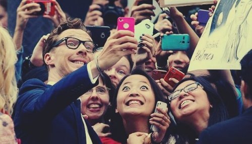 Benedict Cumberbatch taking a picture with some fans.