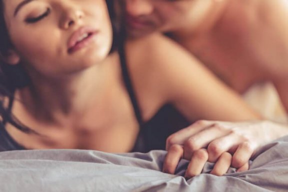 kvinde der bliver kærtegnet af mand i seng