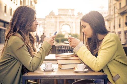 Two girls looking at their phones.