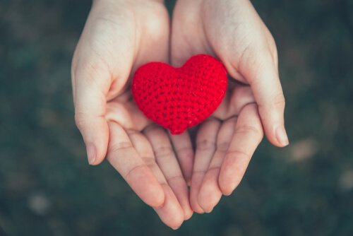 Two hands holding a crocheted heart.