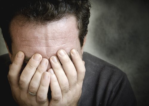 A man burying his face in his hands.