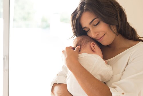 A mother holding her baby tenderly.