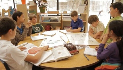 A group of kids doing school work.
