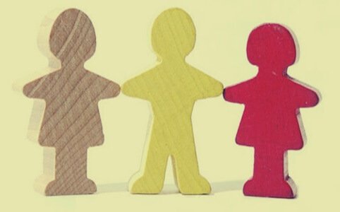 Three paper doll figures holding hands.