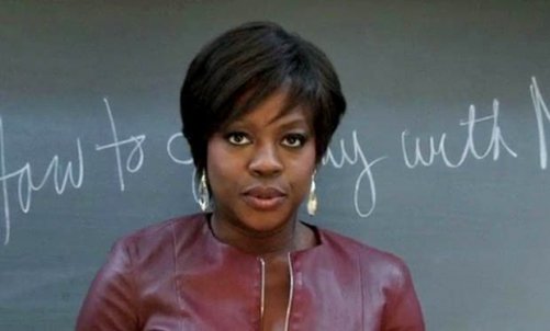 Annalise Keating in front of a chalkboard.