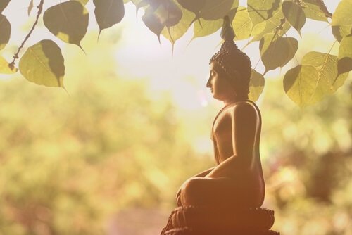 A statue of Buddha under a tree.