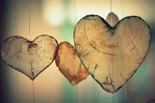 Three wooden hearts hanging on string.