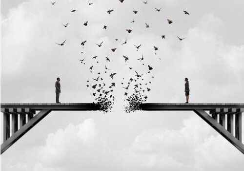 A couple standing on a broken bridge.