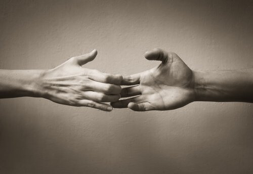 Hands holding on by the fingertips.