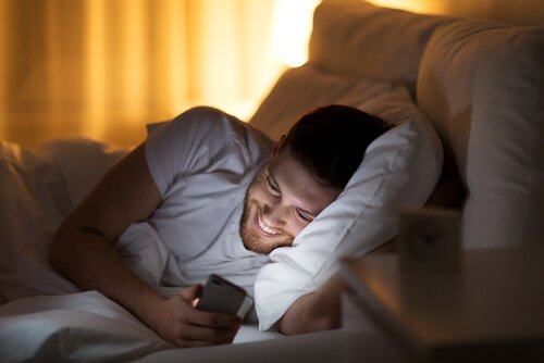 A man looking at his phone laughing.