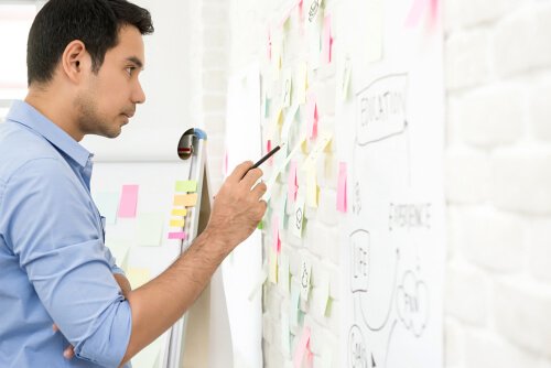 A man looking at notes on a board.