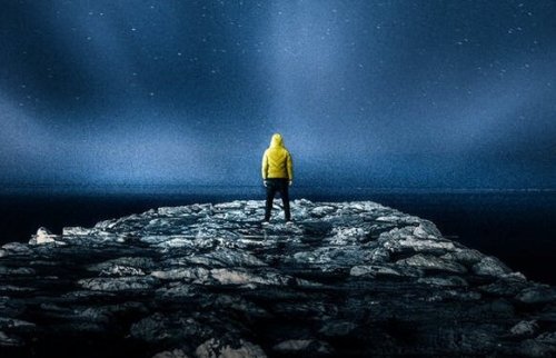 mand på isflager i havet, der kigger på nordlys og tænker over selvrealisering