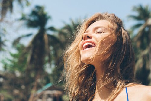 A woman basking in the sunlight, feeling happy.