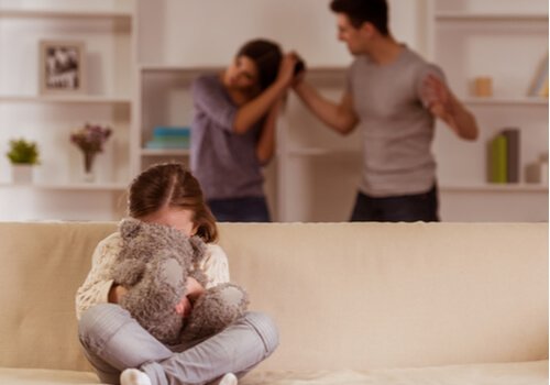 A girl hiding behind her stuffed animal as her parents fight in the background.