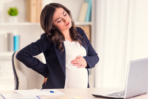 A stressed pregnant woman at her office.