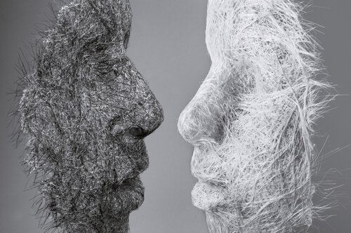 An image of a black mask and white mask facing each other symbolizing the idea that we can change our personality.