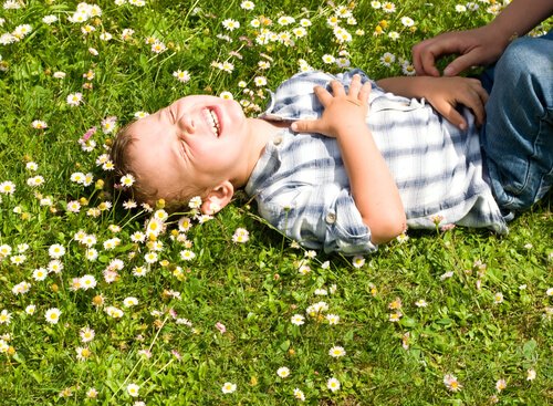 A boy in a field laughing due to a Gianni Rodari quote.