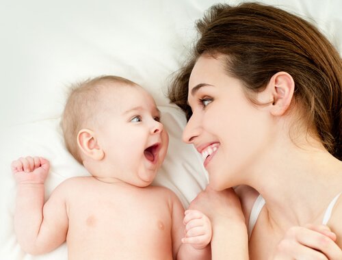 A woman and a baby smiling at each other.