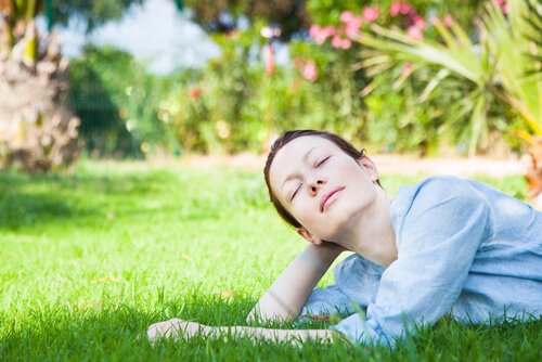 A woman on the grass, soaking up the sun.